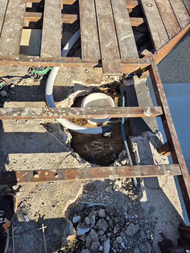 Tuyauterie des skimmers passée sous la terrasse, prête à être raccordée