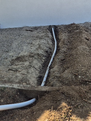 Nouvelle canalisation de skimmer installée dans la tranchée avant remblaiement